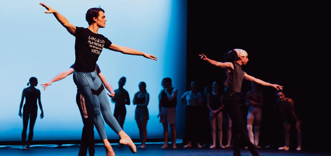 A group of ballet dancers on stage practicing for an upcoming performance.